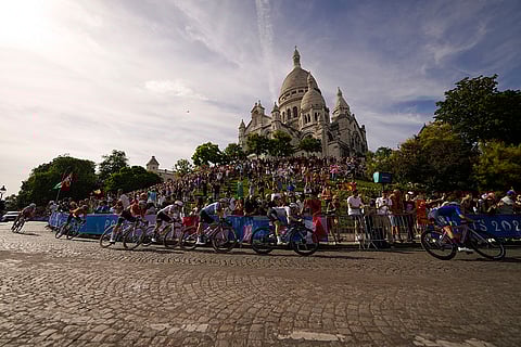 Competitors ride past the Sacre Coeur basilica, during women's road cycling